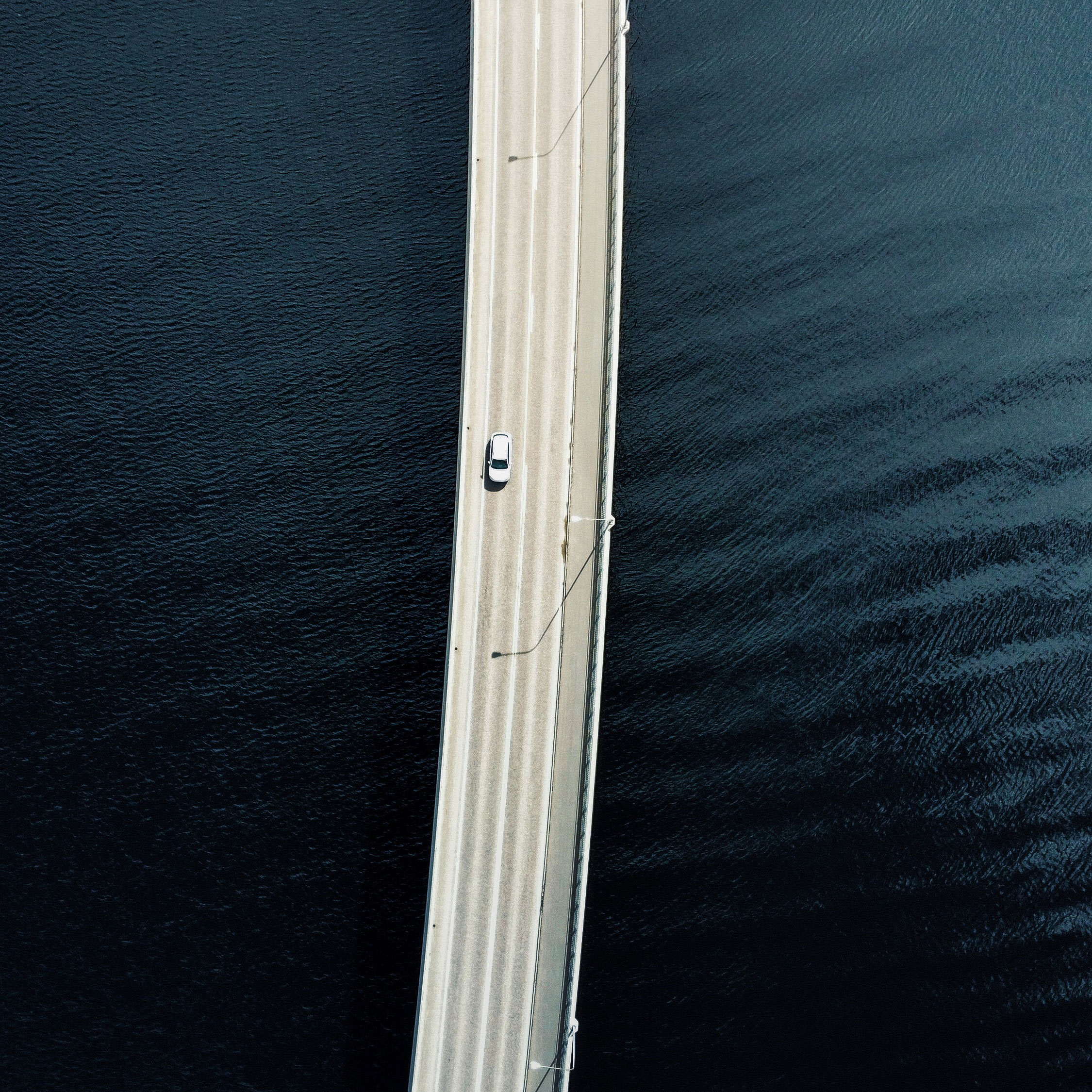 Auto fährt auf Brücke über Meer